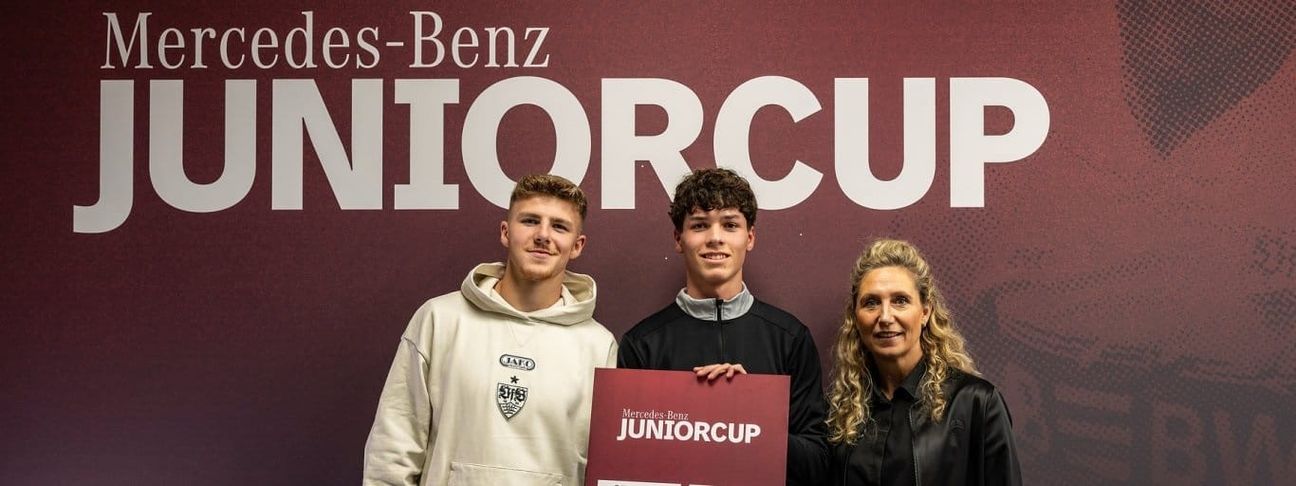 VfB-Profi Finn Jeltsch (links) und Sara Gielen, Leitung Produktion Mercedes-Benz Werk Sindelfingen und Standortverantwortung, losen gemeinsam die Gruppen für den Mercedes‑Benz Junior Cup 2026 aus.