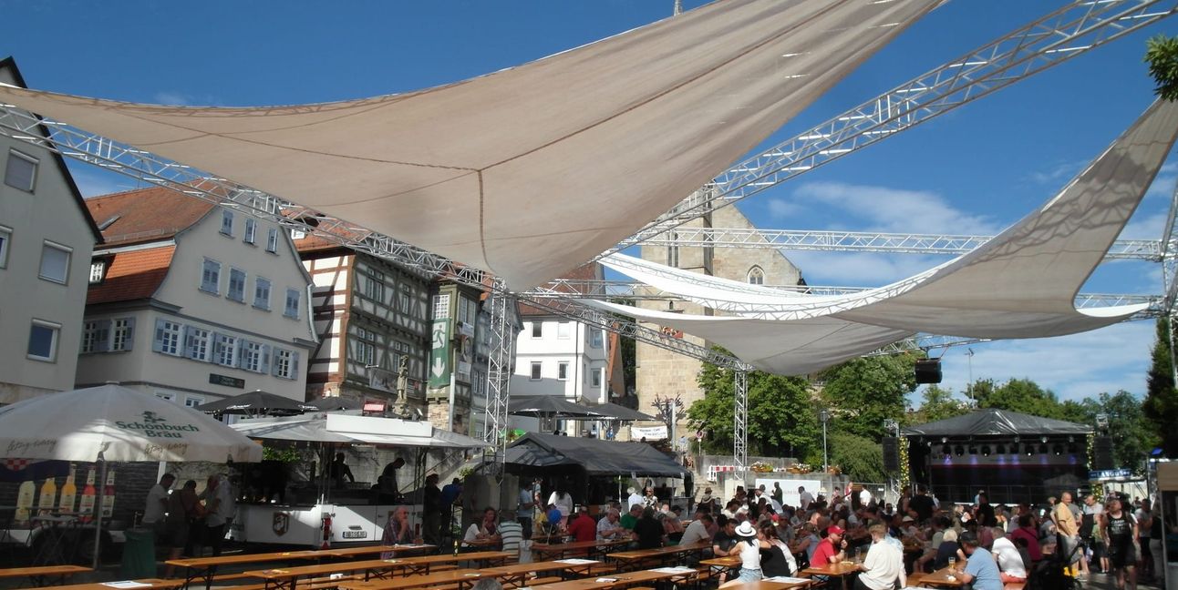 Wie wichtig bei Feiern im Sommer mittlerweile schlüssige Verschattungs-Konzepte sind, hat die 42. Auflage des Stadtfestes Böblingen am Wochenende eindrücklich unter Beweis gestellt - wie hier am Samstagmittag auf dem Martkplatz, wo sich die Besucher im Schatten der Sonnensegel drängen, während die Garnituren in der Sonne leer bleiben.