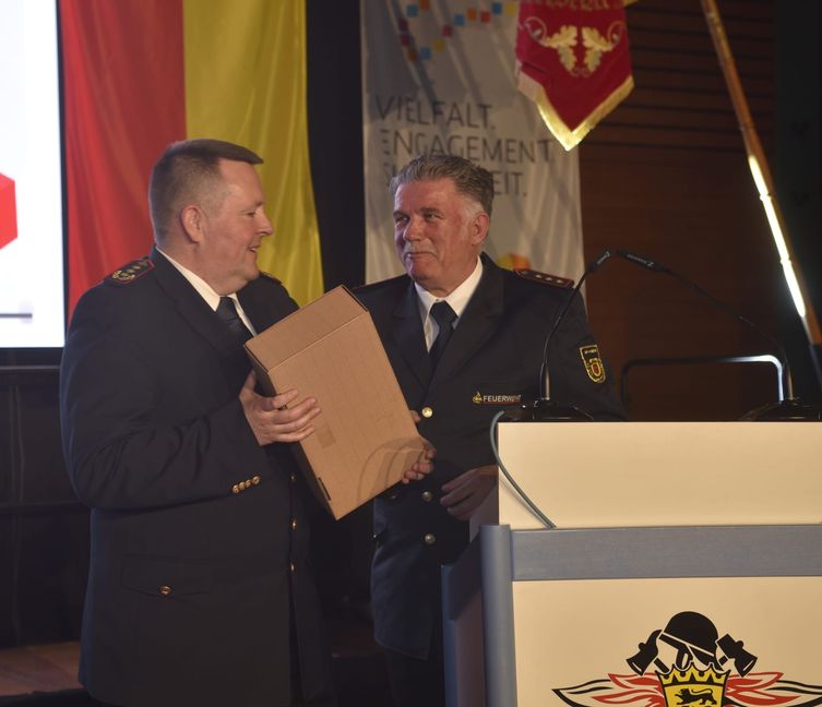 Michael Wegel (links) , der Präsident des Landesfeuerwehrverbands, verbrachte seinen Geburtstagsabend bei der Delegiertenversammlung des Feuerwehrkreisverbands Böblingen. Dessen Vorsitzender Markus Priesching (rechts) gratulierte ihm mit einem Weingeschenk.
