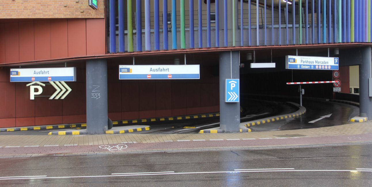 Der Blick auf die Einfahrt des Parkhauses von der Insel des Kreisverkehrs aus: Die ein- und ausfahrenden Autos belasten den Belag über Gebühr.