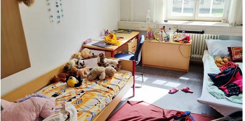 Погляд на кімнату дівчинки: багато м’яких іграшок перетворюють холодну барачну кімнату в теплу дитячу. Зображення: Хаманн