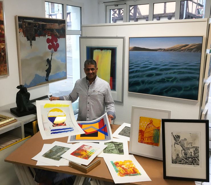 Hesham Hassan mit seinen Schätzen im Kunsthaus: vor ihm die Sindelfingen-Serie von Isabel Hennerich und Drucke von Otto Herbert Hajek, hinter ihm Originale von Michael Krähmer und C-Print von Joachim Kupke.    Bild: P. Bausch