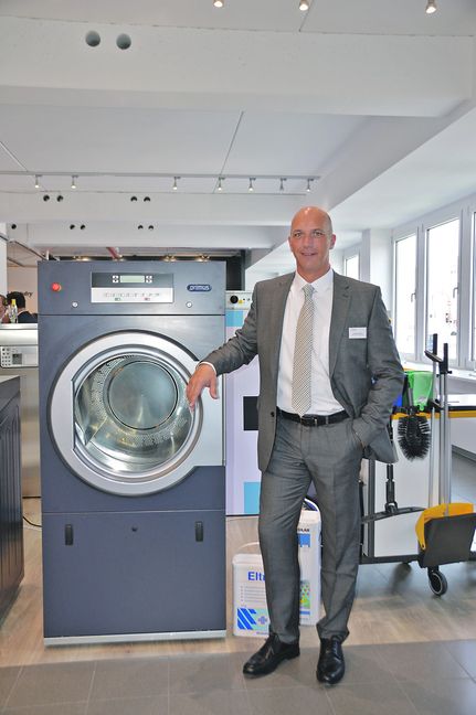 Niederlassungsleiter Christoph Kampmann mit einer der Wäscherei-Maschinen, die Alliance Laundry für den deutschen Markt produziert. Bild: Reichert