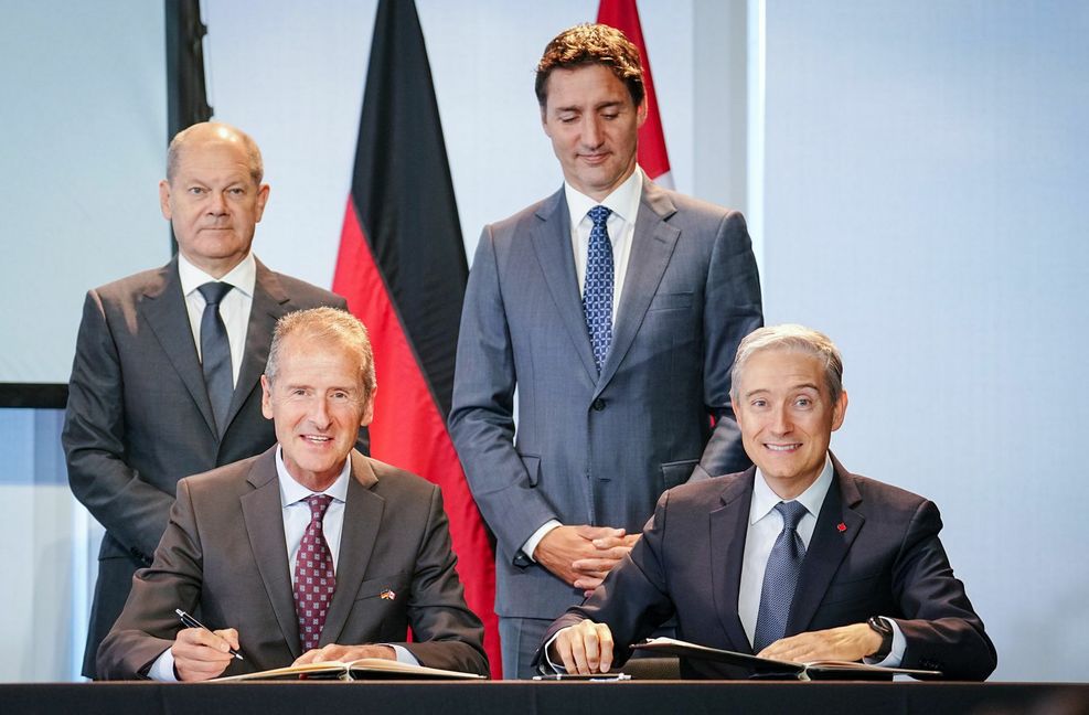 Noch-VW-Chef Herbert Diess (vorne links) beim Unterzeichnen einer Absichtserklärung. Im Hintergrund die Regierungschefs Olaf Scholz und Justin Trudeau.