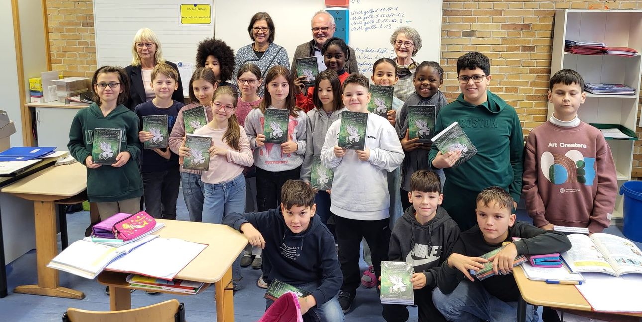 Die Klasse 4b der Gemeinschaftsschule Eichholz mit ihren Büchern. Hinten stehen (von links)  Sabine Mundle, Hanna Bacherle, Dr. Karl Peter Hoffmann, Ingrid Bitter.