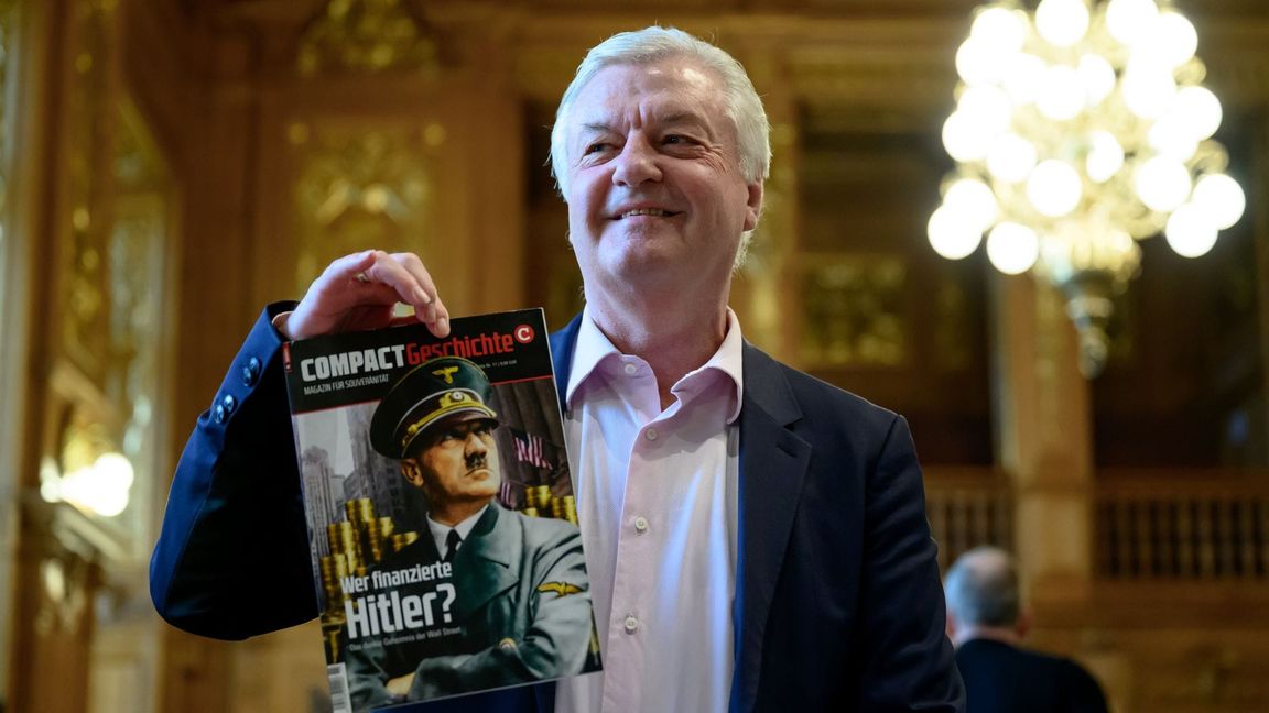 "Compact"-Chefredakteur Jürgen Elsässer hält im Bundesverwaltungsgericht in Leipzig eine Ausgabe seines Magazins "Compact Geschichte" in der Hand. (Archivbild)