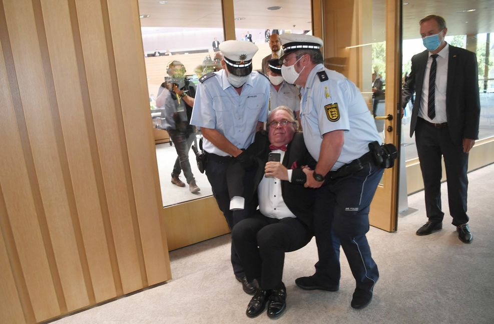 Der Ex-AfD-Abgeordnete Heinrich Fiechtner wird im Juni 2020 von Polizisten aus dem baden-württembergischen Landtag getragen. Zuvor wurde er von der Sitzung ausgeschlossen, hatte sich aber geweigert  zu gehen.