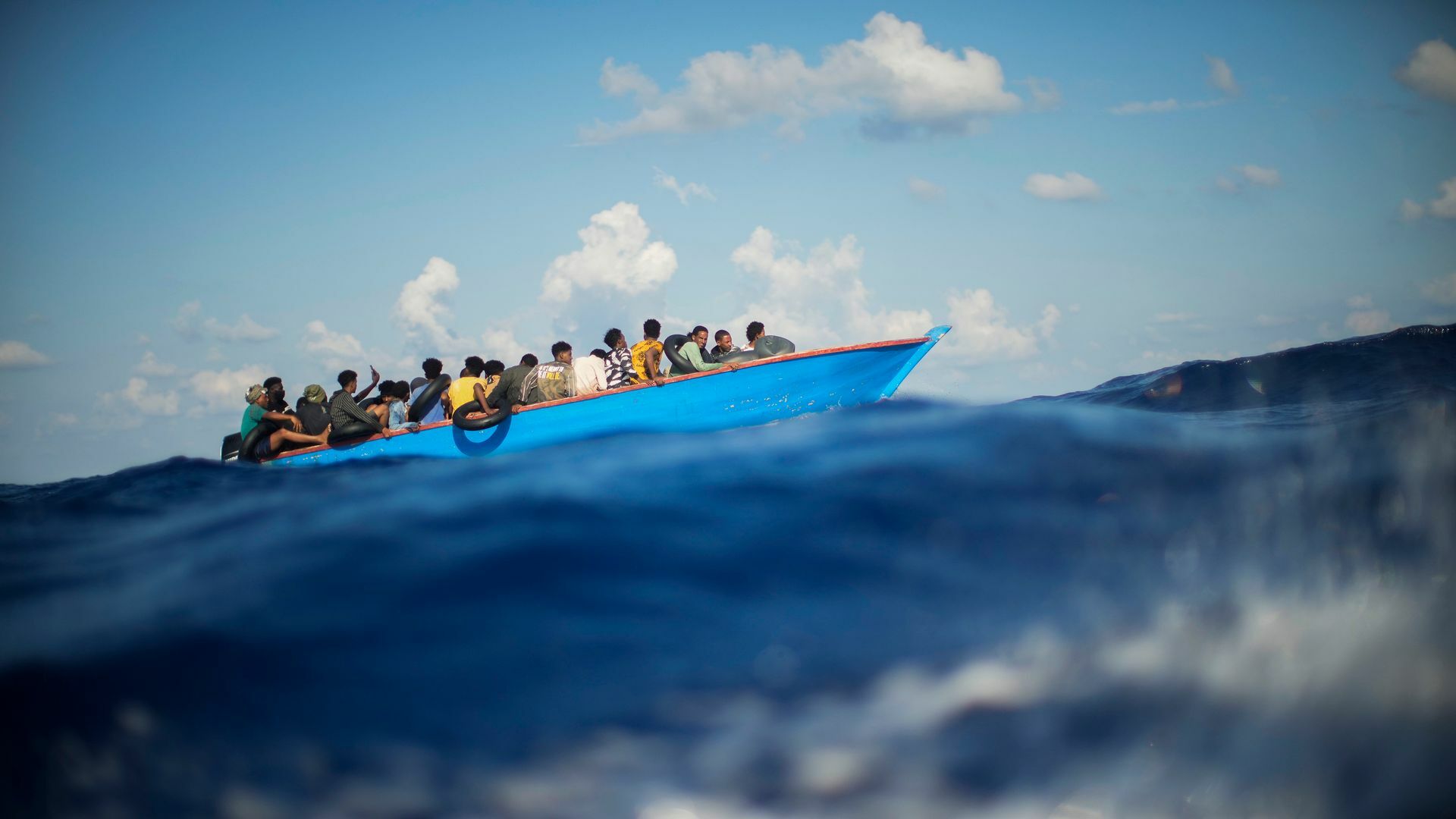 Migranten sitzen in einem Holzboot im Mittelmeer nahe der Insel Lampedusa: Die kleine Insel gehört seit Jahren zu den Brennpunkten illegaler Migration (Archivfoto).