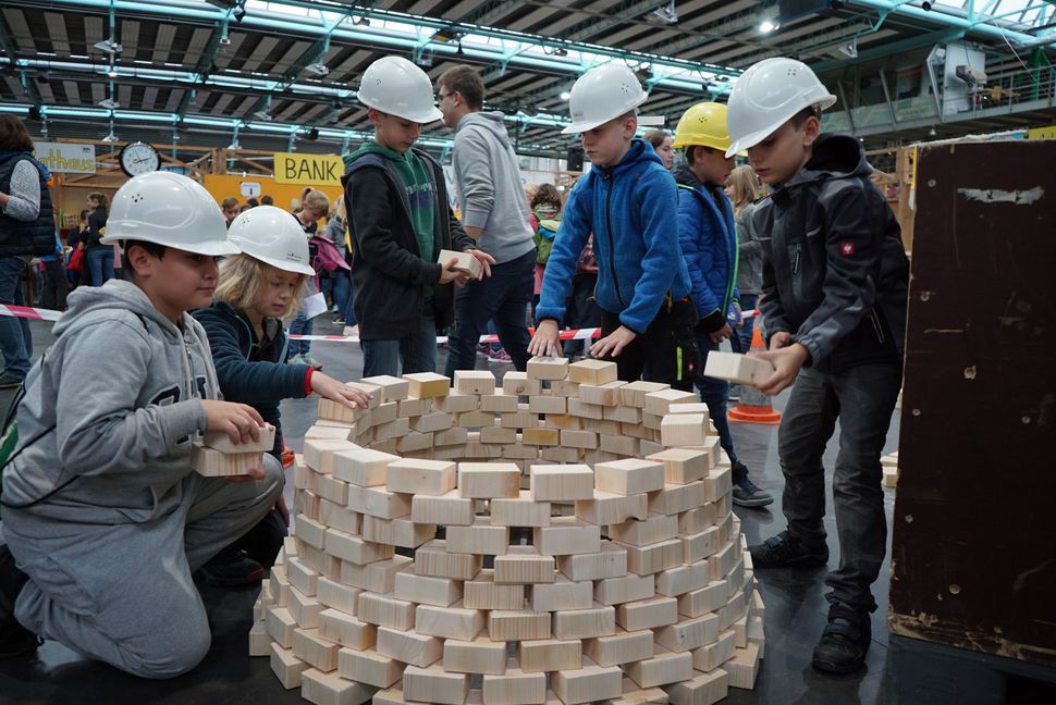 Die Jungs vom Holzbau stapeln kurz nach Simsalon-Start schon einen Pyramidenturm aus Holzklötzen. 	Bilder: Heiden