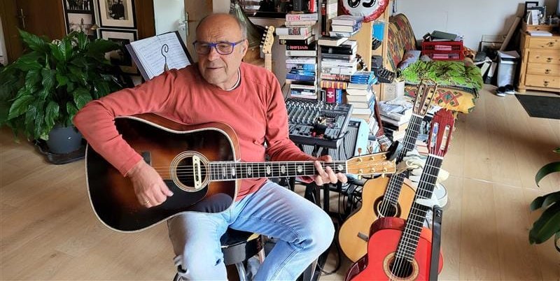 Manfred Müller mit seinen geliebten Gitarren. Im Hintergrund stapeln sich die Krimis.Bild: Cardoso