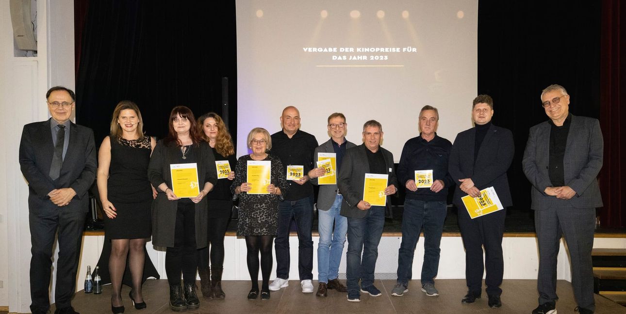 Bei der Preisübergabe im Tübinger Kinomuseum (von links): MFG-Geschäftsführer Carl Bergengruen und Moderatorin Alexandra Staib, außerdem  Ralf Merkel (Vierter von rechts), Johann Manz, Andreas Zienteck von den Böblinger Kinos sowie Staatssekretär Arne Braun.