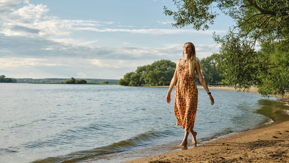 Eine Frau spaziert barfuß am Sandstrand: Der Bund für Umwelt und Naturschutz Deutschland gibt Ratschläge für einen abfallarmen Urlaub (Symbolfoto).