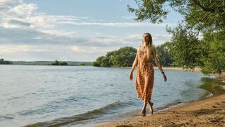 Eine Frau spaziert barfuß am Sandstrand: Der Bund für Umwelt und Naturschutz Deutschland gibt Ratschläge für einen abfallarmen Urlaub (Symbolfoto).