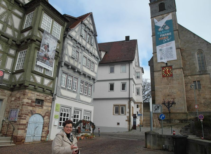Stadtkirchen-Pfarrerin Gerlinde Feine zeigt, was es mit dem neuen Banner an der Böblinger Stadtkirche auf sich hat: Der QR-Code auf dem Banner läst sich scannen und verweist auf die Homepage mit den Angeboten der Evangelischen Kirche Böblingen.