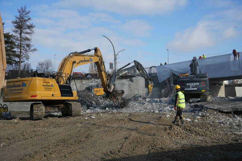 Neugierige Menschen beobachten das Geschehen: Einen Brückenabriss sieht man auch nicht alle Tage.