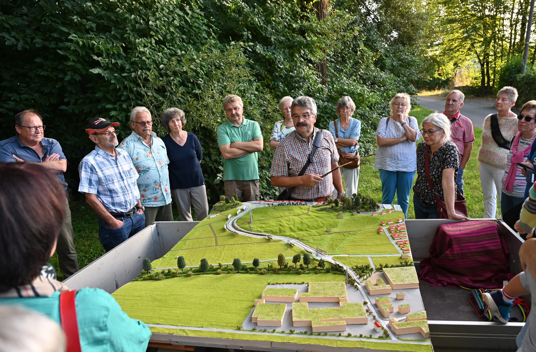 Magstadts früherer Bürgermeister Dr. Hans-Ulrich Merz (kariertes Hemd) erläutert am Modell der Osttangente die Planungen der Gemeinde zum Schutz vor Hochwasser.  Bild: Reichert