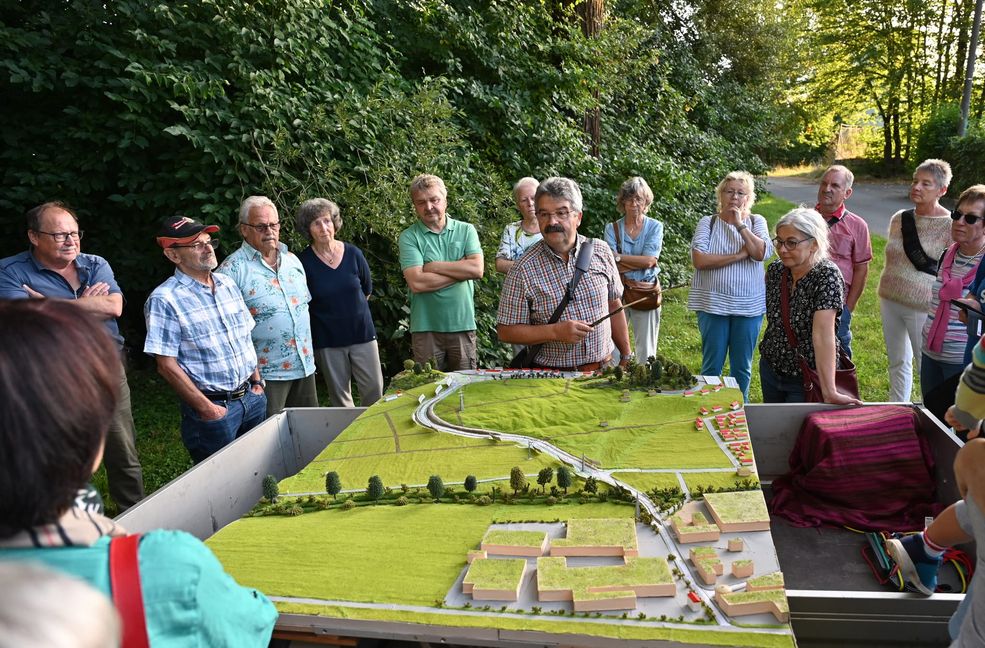 Magstadts früherer Bürgermeister Dr. Hans-Ulrich Merz (kariertes Hemd) erläutert am Modell der Osttangente die Planungen der Gemeinde zum Schutz vor Hochwasser.  Bild: Reichert