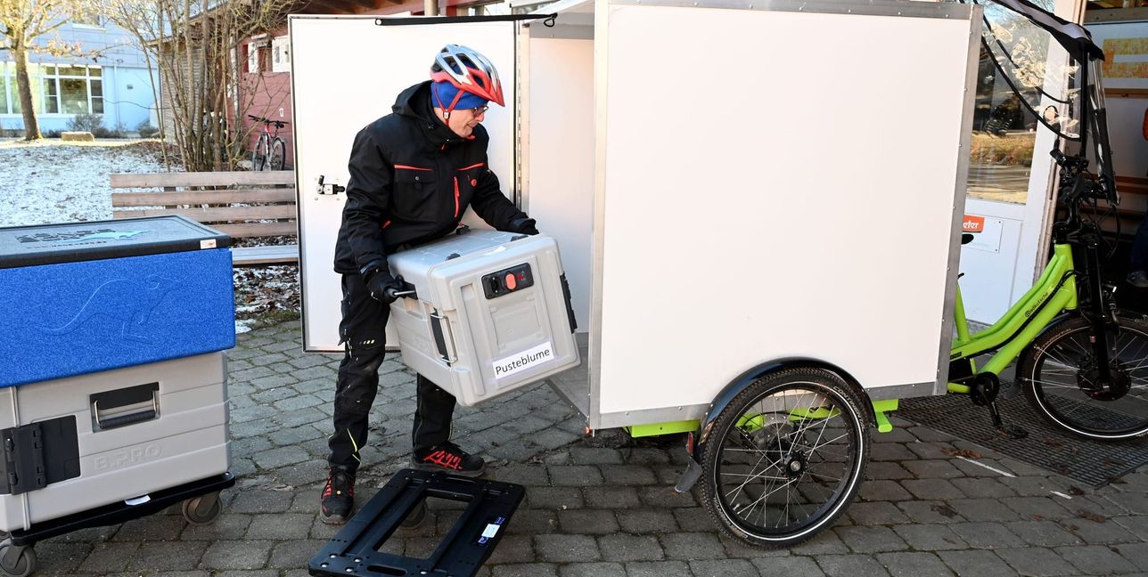 Daniel Kuttler verlädt die Essensboxen in die Radkutsche.