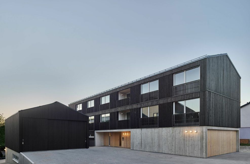 Nachverdichtung und die Belebung eines dörflichen Zentrums in Schweikheim wurde mit diesem Projekt belohnt. Das Wohn- und Werkhaus Weilerstraße von CAPE Binder Hilllnhütter Deisinger  mit Schleicher Ragaller Architekten ist hoch gedämmt und  kommt dank Wärmepumpe und PV-Anlage in der Jahresbilanz auf Nullenergiestandard. Das Ensemble verfügt über Mietwohnungen in Holzbauweise . . .