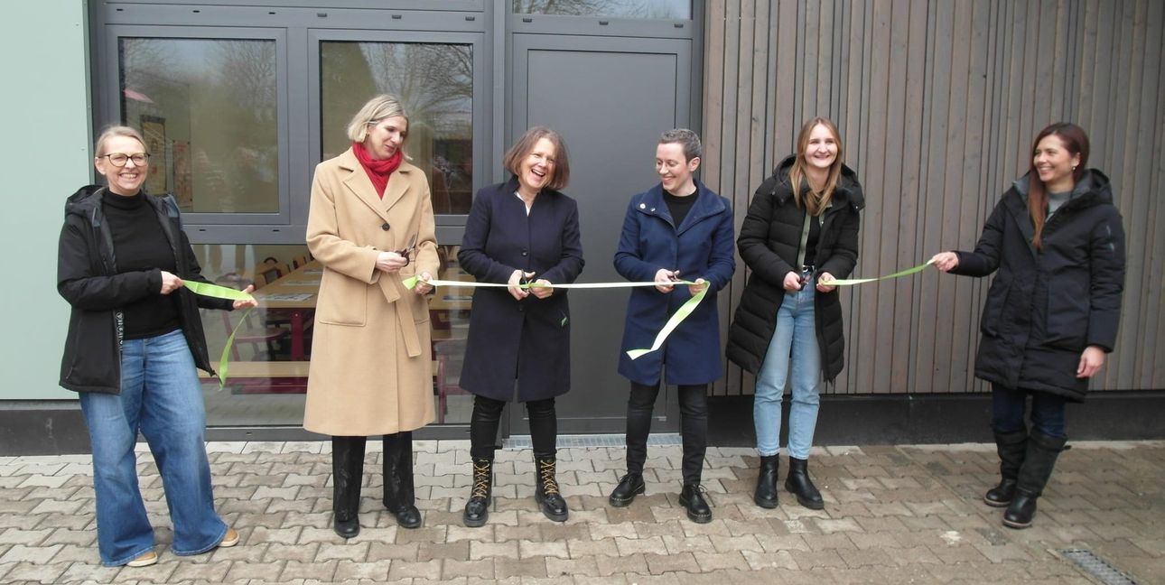 Ein Band für den Erweiterungsbau: Marcela Bareither-Frenzel (Projektleiterin), Svenja Hauser (Schulleiterin), Bianca Gruber (Erste Beigeordnete), Bürgermeisterin Anna Walther, Julia Kreidler (Projekt-Architektin), Nami Kriegel (Projekt-architektin/von links).