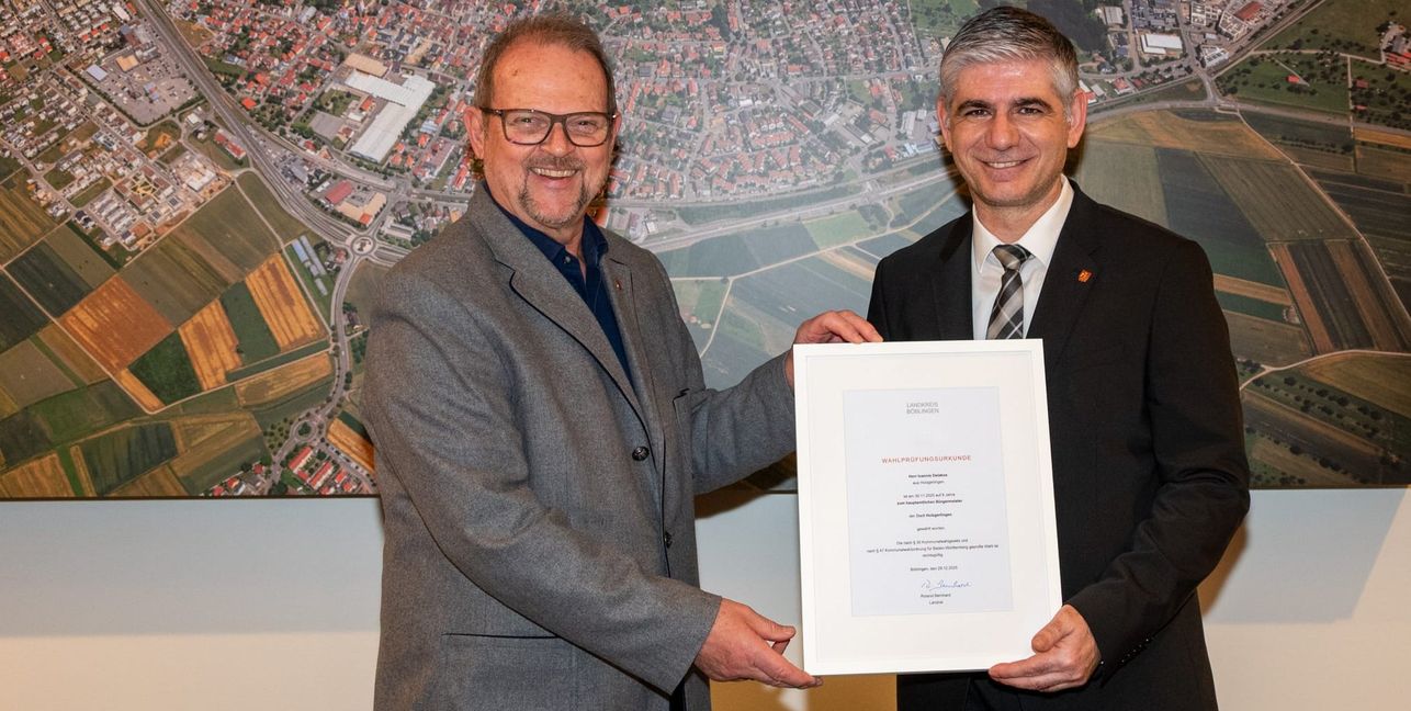 Der stellvertretende Bürgermeister Eberhard Binder überreicht Bürgermeister Ioannis Delakos die offizielle Wahlprüfungsurkunde.