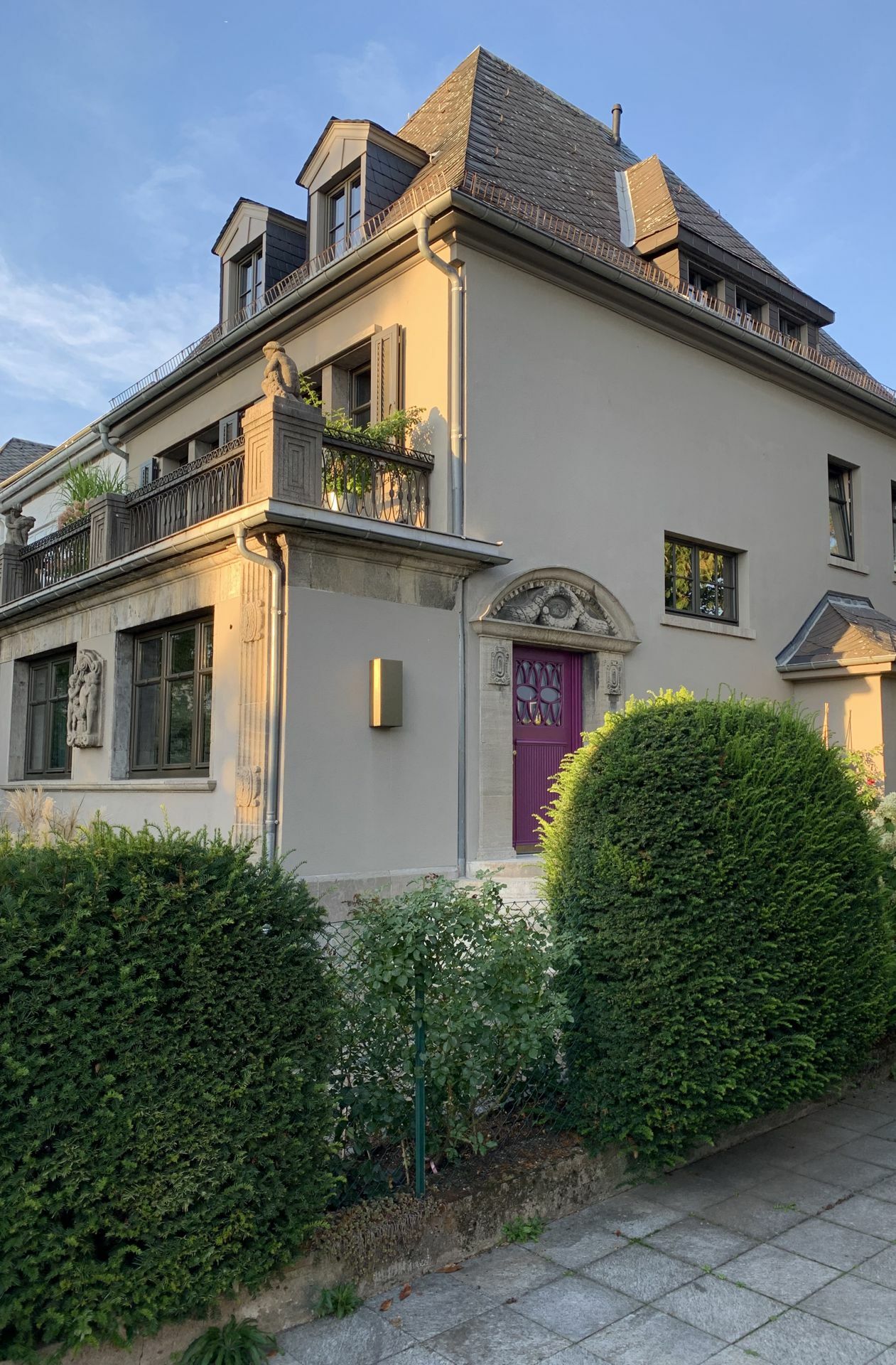 Innenarchitekt Jan Leithäuser hat das Einfamilienhaus aus dem Jahr 1912 in Frankfurt am Main umgebaut; der Putz und die Fensterrahmen orientieren sich an der Farbe des Sockels aus Muschelkalk. Die himbeerfarbene Tür setzt sich davon apart ab.