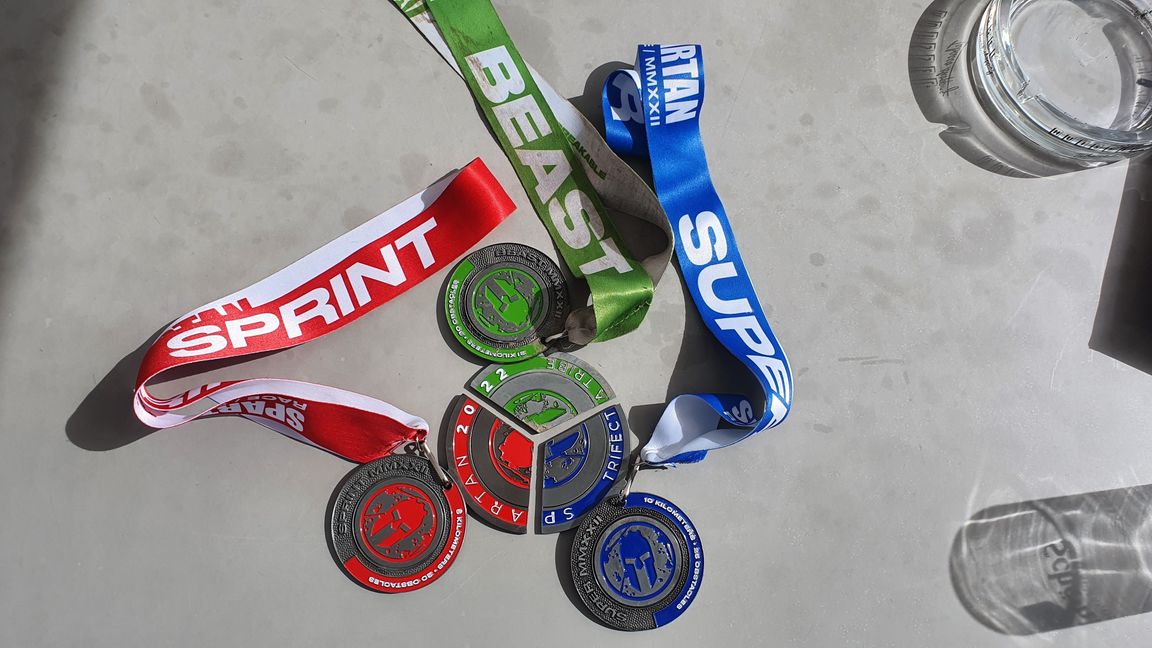 3 der 10 Medaillen von Dominic Schaudt: „Sprint“ rot, „Super“ blau, „Beast“ grün – wenn man alle drei Strecken meistert, schließt sich der Kreis.      Bild: Wegner