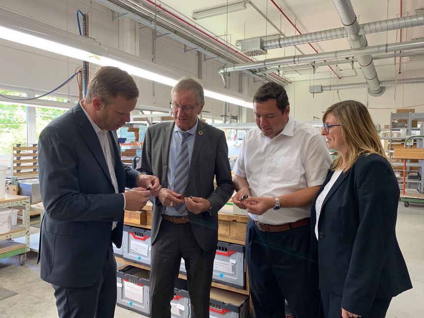 Landrat Roland Bernhard (Zweiter von rechts) und Bürgermeister Thomas Riesch Zweiter von links) mit Christian Mayer (COO der Louis Renner GmbH) und Sabine Manal (CFO der Louis Renner GmbH  bei der Betrachtung von Louis Renner-Dämpferpüscheln. Bild: z