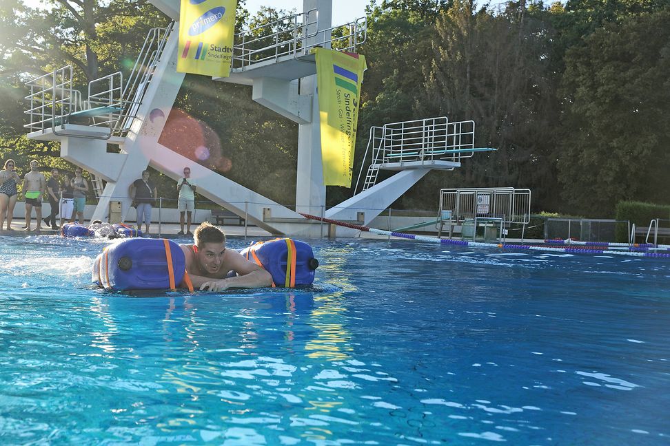 Auf dem selbst zusammengebauten Floß geht es durch das Springerbecken im Sindelfinger Freibad. Bild: Dettenmeyer