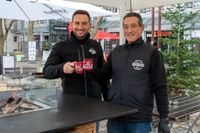 Salvatore (links) und Francesco Romeo stoßen am Currytruck mit ihrem frisch zubereiteten Glühwein an.
