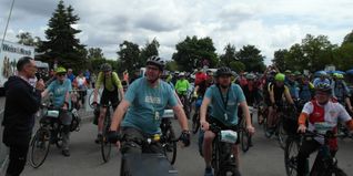 Organisator Albrecht Röder (links, mit Mikro) und Maichingens Ortsvorsteher Wolfgang Stierle (rechts, mit VfB-Trikot) beim Start der „Jubiläums-Radtour von Maichingen nach Hirsau“ im Rahmen des Festprogramms „950 Jahre Maichingen“. Bild: Staber