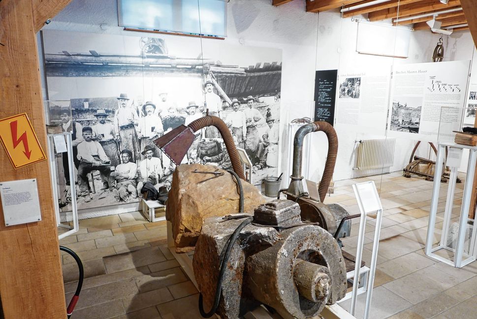 Diese Absauganlage sollte die Gefahr der Staublunge bei den Arbeitern verringern. Im Hintergrund stolze Dettenhäuser Steinhauer um 1900.