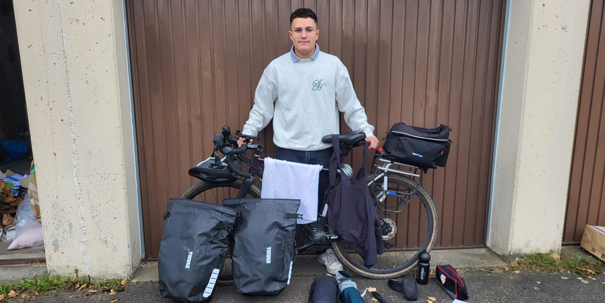 Nael Winterhalter vor seiner Garage mit seinem Gravel-Bike, und seiner Ausrüstung  	  Bild: Cardoso