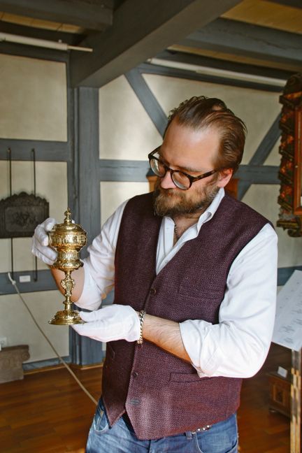 Museumsleiter Christian Baudisch und dr Maulbronner Zunftpokal.	Bild: Jung