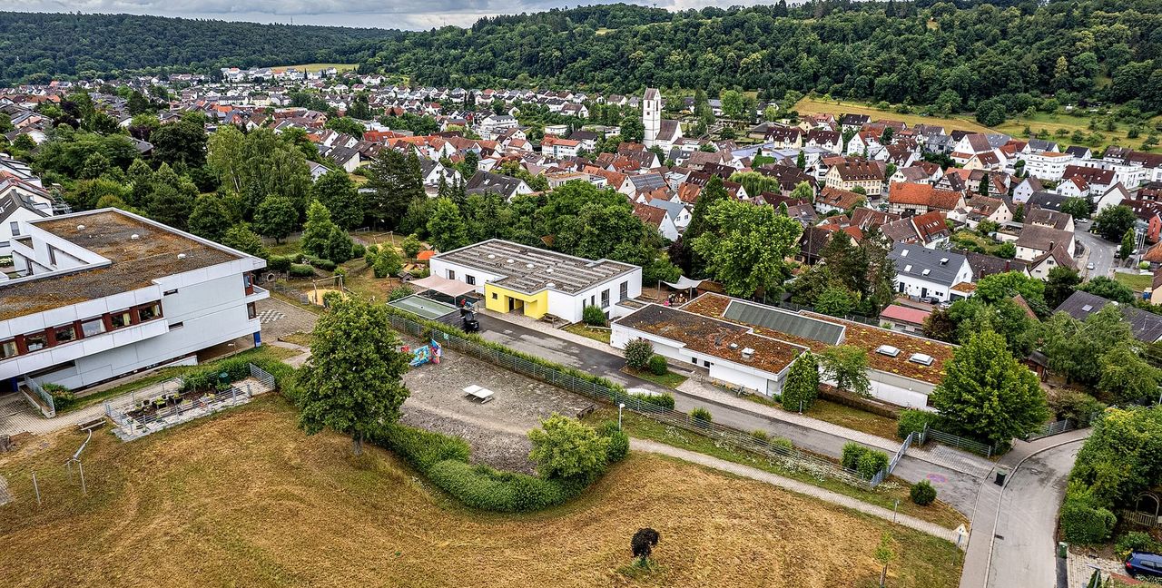 Auf dem freien Gelände unterhalb der Sonnenbergschule (links) und dem Kindergarten (Mitte) soll das neue Wohn- und Pflegequartier in Aidlingen entstehen.