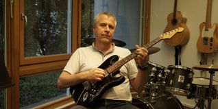Wieland Harms mit Gitarre vor Schlagzeug.