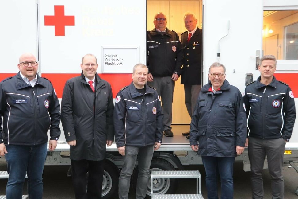 Freuen sich über Neuanschaffung (von links): Geschäftsführer Wolfgang Hesl, Vizepräsident Dr. Bernd Vöhringer, Kreisbereitschaftsleiter Jörg Männer, Bereichsleiter Klaus-Dieter Grossnick und stellvertretender Kreisbereitschaftsleiter Ulrich Schweidler (beide im Türrahmen), Präsident Michael Steindorfner und stellvertretender Kreisbereitschaftsleiter Marc Lerner.   Bild: DRK