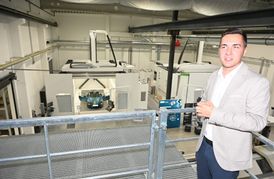 Vorstand Marius Müller auf der Galerie des neuen Technologiezentrums von Silberform. Der Porsche unten steht in einer Kabine der Fräsmaschine, die bis zu acht Meter lange, 3,5 Meter breite und 2,75 Meter hohe Bauteile zerspanen kann.