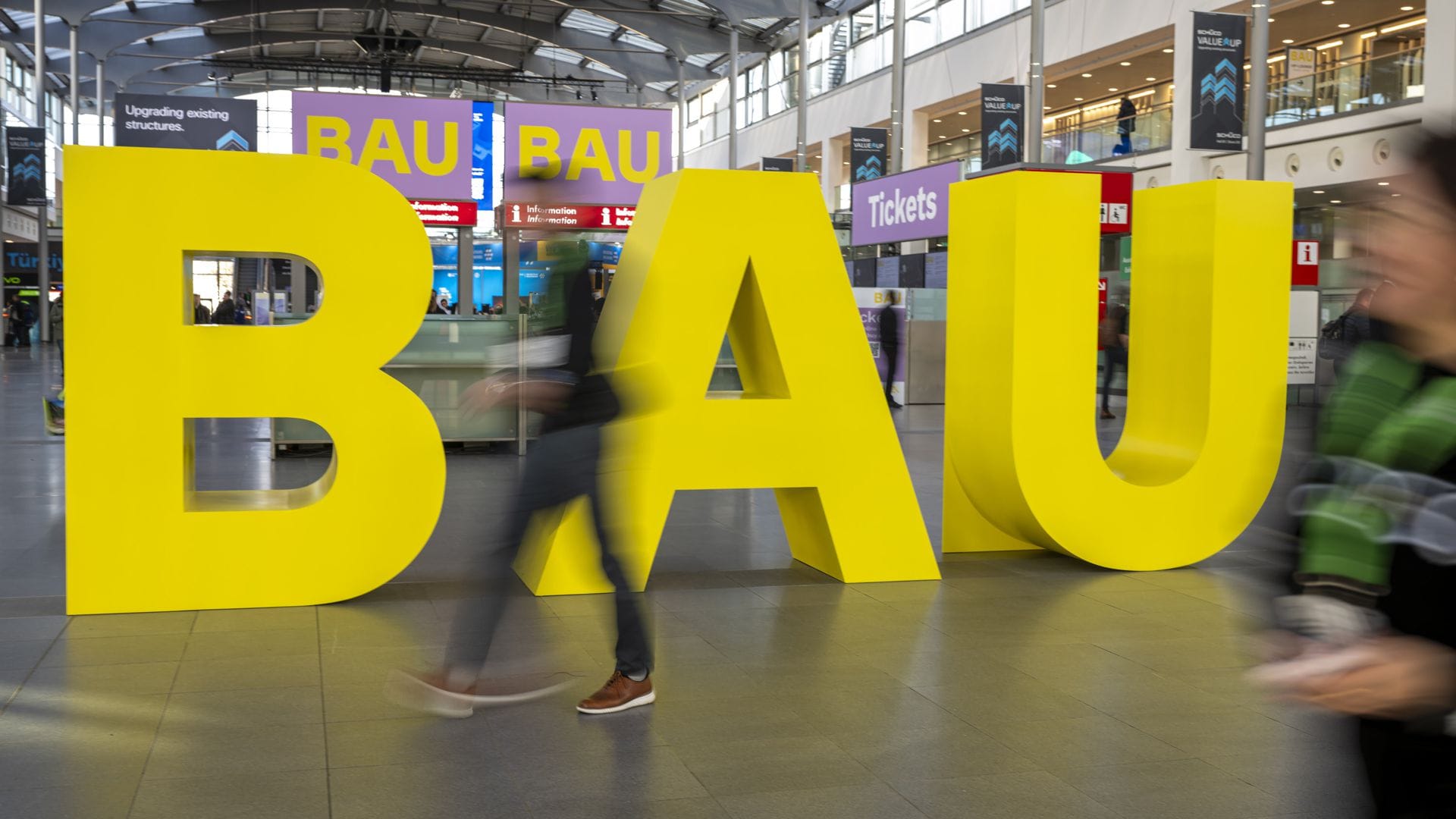 Gelbe Buchstaben stehen am Eingang der Messe „Bau 2025“.