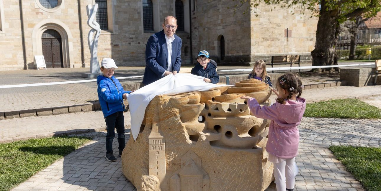 Oberbürgermeister Dr. Bernd Vöhringer mit Kindern der Kita Klostergarten beim Enthüllen des Murmelsteins.