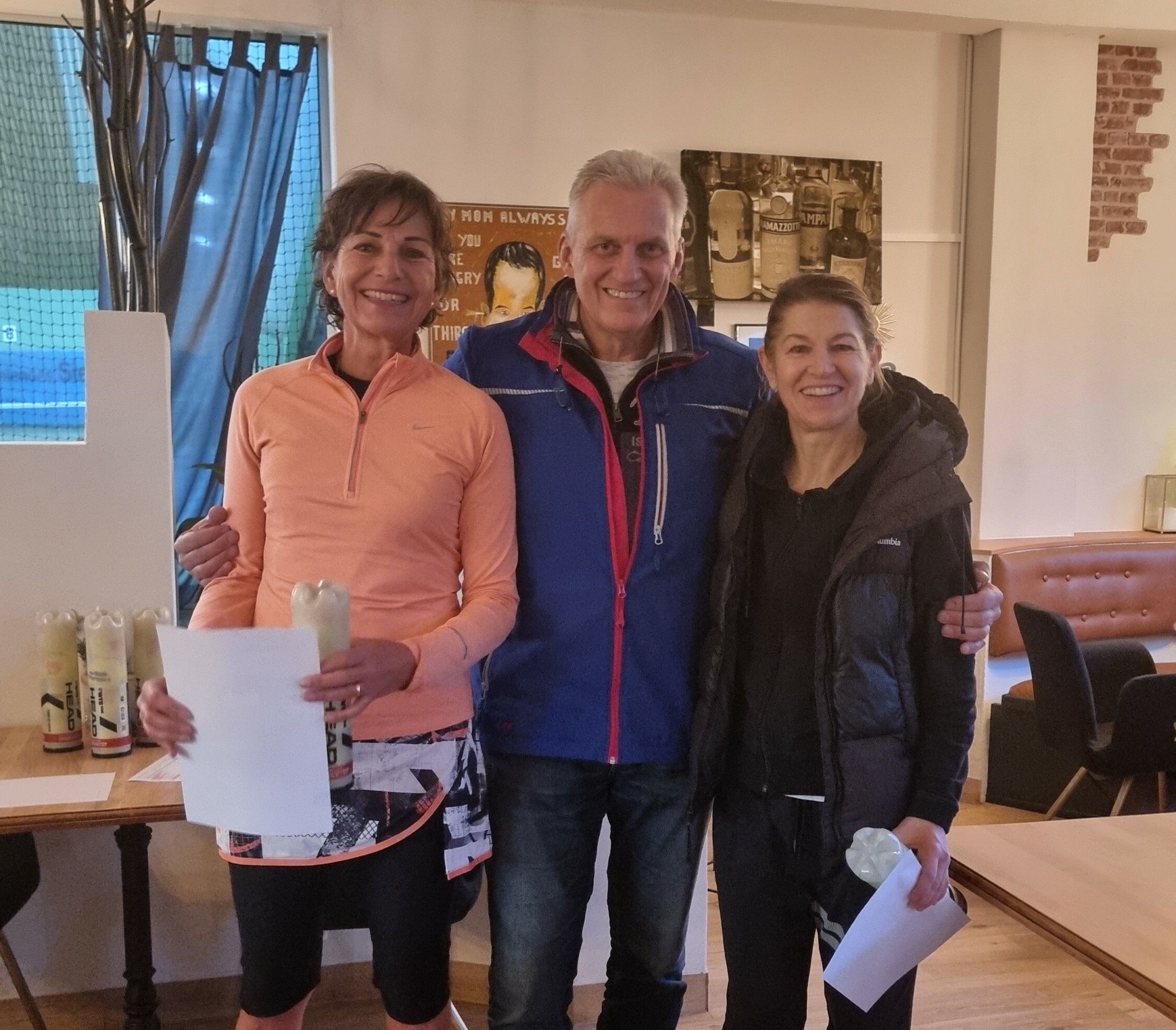 Stefanie Jäger (TC Schönaich, links) trug sich bei den Winter-Open der TA VfL Sindelfingen bereits zum dritten Mal in die Siegerliste ein. Gratulantin war neben Turnierleiter Boris Clar auch die Zweitplatzierte Simone Hellstern (TEC Waldau). Bild: z