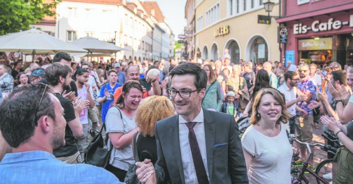 Nach dem Wahlsieg bei der Freiburger OB-Wahl nehmen Martin Horn und seine Frau Irina (rechts) vor dem Rathaus ein Bad in der Menge. Wenig später wurde der neue OB von einem 54-Jährigen attackiert und verletzt. Bild: Fionn Große