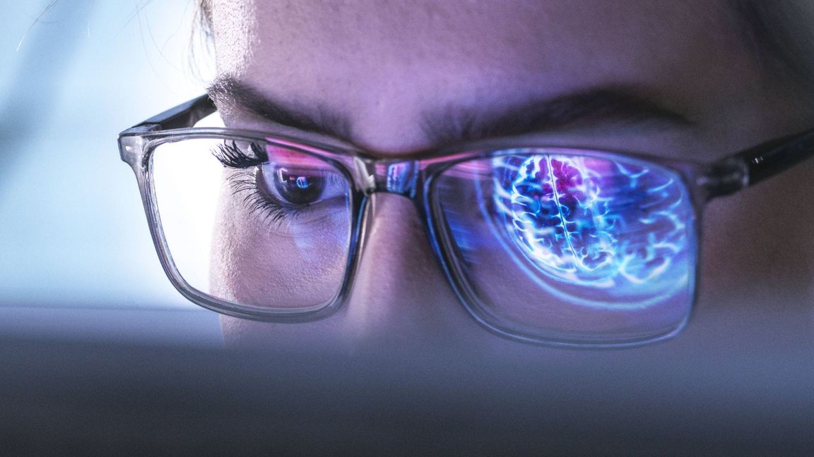 Ein Arzt untersucht mit Hilfe einer KI die Abbildung eines menschlichen Gehirns.