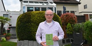 Manfred Maurer mit seinem Taschenbuch über die eigene Energiewende. Im Hintergrund die Doppelhaushälfte mit der PV-Anlage. Solarpaneele wurden natürlich auf der Südseite, aber auch auf der Nordseite und auf dem Garagendach installiert