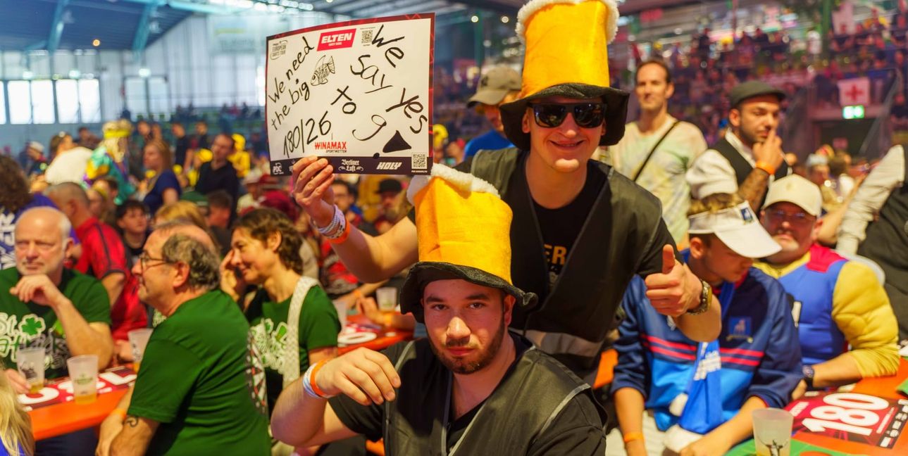 Ausgefallene Verkleidungen und beschriftete Schilder gehören beim Darts zum Programm.