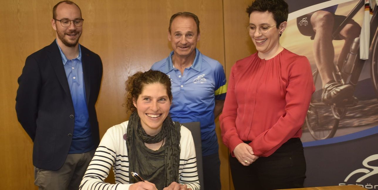 Lisa Brandau trägt sich als Erste ins neue Goldene Buch der Gemeinde Schönaich ein – unter der Aufsicht von Bürgermeisterin Anna Walther (von rechts), Freddy Eberle (Vorsitzdender des RSC Schönaich) und dessen Stellvertreter Tim Müller.   
Bild: Reichert