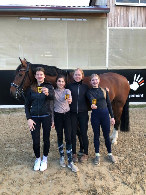 Celine Dostal, Aliya Akyüz, Trainerin Lisa Müller und Romi Schürr vor einem Schulpferd des Reit- und Fahrvereins Böblingen.