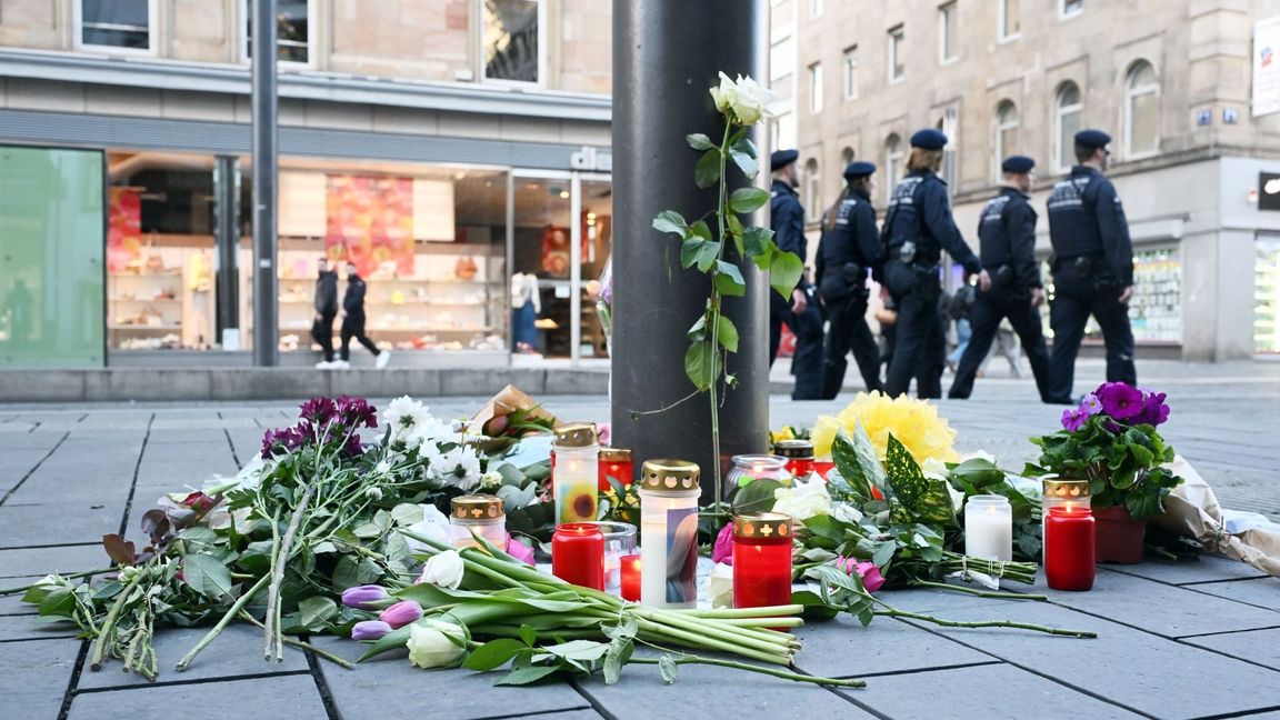 Kerzen und Blumen liegen in der Nähe des Paradeplatzes in Mannheim an einer Straßenbahnhaltestelle. (Archivfoto)