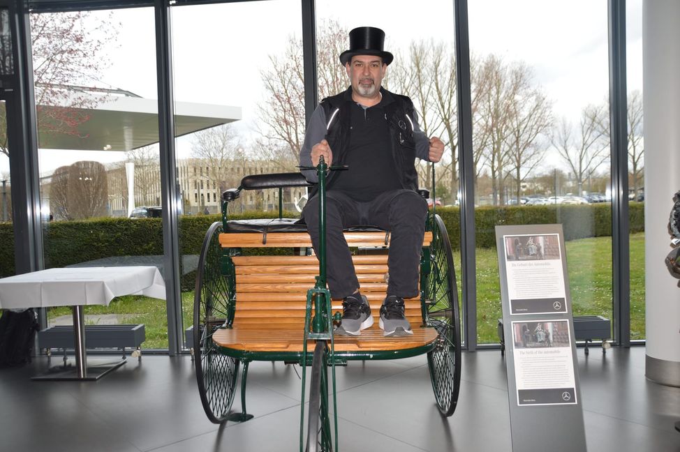 Francesco Frasca sitzt auf einem Nachbau eines Benz-Patent-Motorwagens. Das Fahrzeug ist im Kundencenter des Sindelfinger Mercedes-Benz-Werkes ausgestellt.