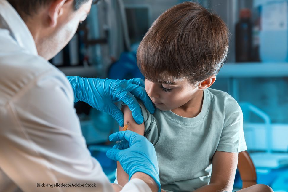 doctor holding syringe subcutaneous vaccine for child in the medical office / pediatrician vaccinating little boy in the pediatric clinic